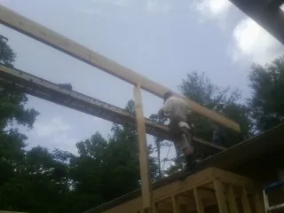 Carpenter setting a ridge beam over a new addition frame — Ice Dam Removal by Roofing Brothers in Texas City