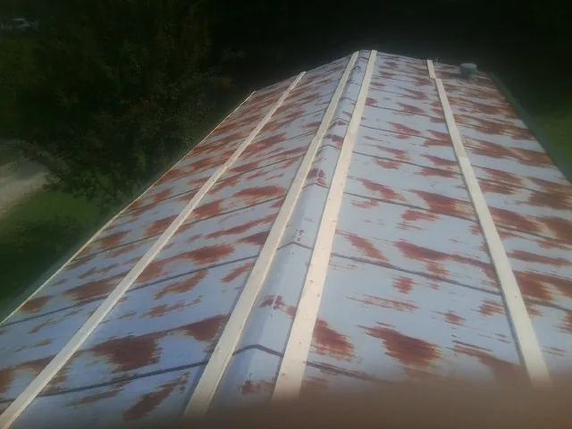 Rusted metal roof panels with new wood purlins before replacement — Storm Damage Roof Repair in Texas City by Roofing Brothers