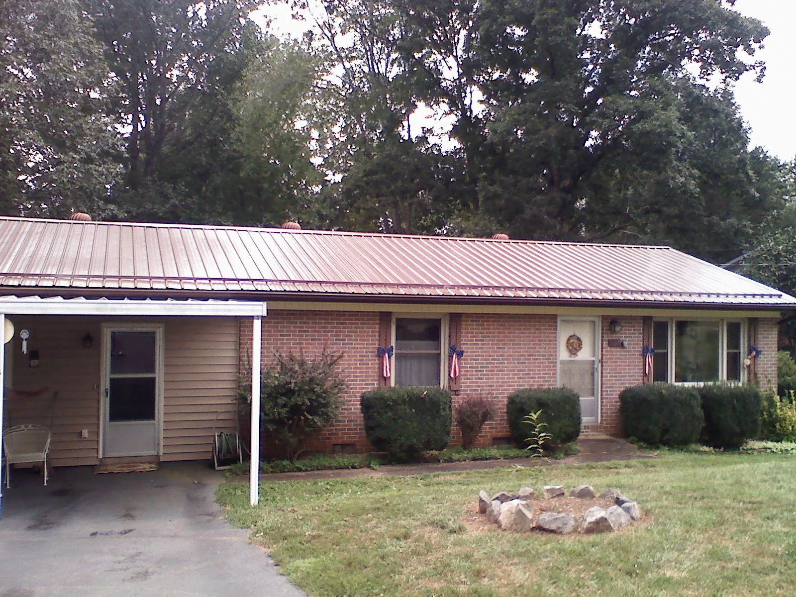Bronze metal roof and carport on a brick ranch home — Roof Repair work by our crew in Texas City