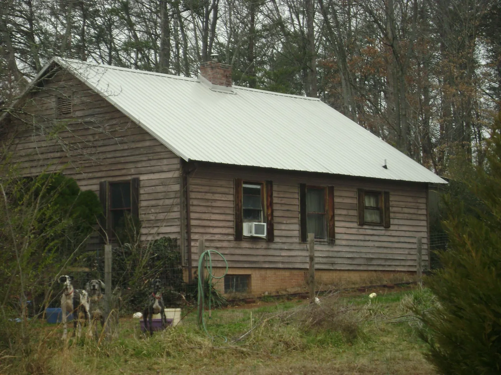 White metal roof on an old wood sided farmhouse, from a Asphalt Shingle Roof Repair job in Texas City